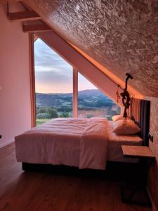 een bed in een kamer met een groot raam bij Lipowe Apartmenty in Limanowa