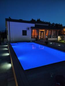 a swimming pool in front of a house at night at Palomino house in Sinj