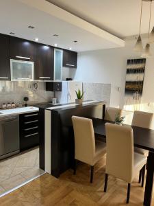 cocina con mesa, 2 sillas y barra en Luxury Apartment, en Mladenovac