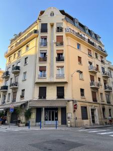 un grand bâtiment jaune au coin d'une rue dans l'établissement Sunshine Getaway - Stylish Studio in the Heart of Nice, à Nice