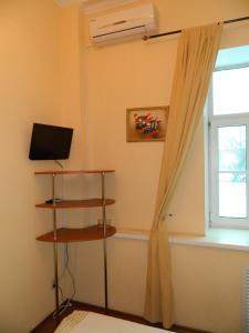 a room with a window and a television and a curtain at Hotel Izumrudniy Gorod in Penza