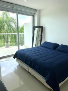 sypialnia z niebieskim łóżkiem i dużym oknem w obiekcie Frente al mar Morros Epic 323 w mieście Cartagena de Indias