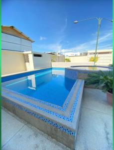 een zwembad met blauwe tegels eromheen bij Departamento amoblado con piscina en San Clemente in San Clemente