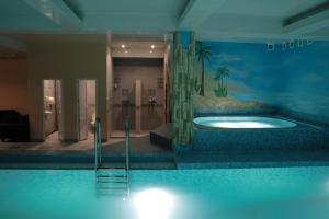 a large swimming pool with a tub in a room at Hotel Izumrudniy Gorod in Penza