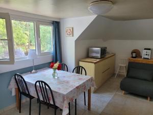 une salle à manger avec une table et des chaises ainsi qu'une cuisine dans l'établissement Cosy one-bedroom apartment in De Haan, au Coq