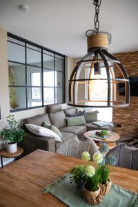 ein Wohnzimmer mit einem Sofa und einem Tisch in der Unterkunft Penthouse Wohnung mit Terrasse & Sauna - Wildecker Ferienbutze in Hönebach
