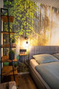 a bedroom with a tree mural on the wall at Penthouse Wohnung mit Terrasse & Sauna - Wildecker Ferienbutze in Hönebach