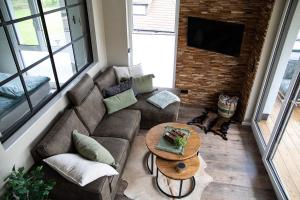 a living room with a couch and a table at Penthouse Wohnung mit Terrasse & Sauna - Wildecker Ferienbutze in Hönebach