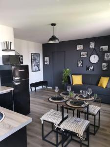 a living room with a couch and a table with wine glasses at LE DEAUVILLE *T2 (40m²) *WIFI*PARKING PRIVE*CALME in Lourdes
