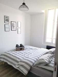 a bedroom with a bed with shoes on it at LE DEAUVILLE *T2 (40m²) *WIFI*PARKING PRIVE*CALME in Lourdes