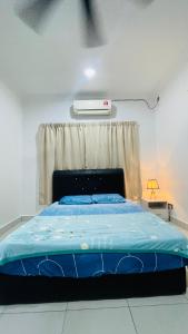 a bedroom with a bed with a blue blanket at Sporting Homestay in Semporna