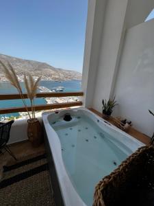 a bath tub in a room with a view of the ocean at Spongia Apartments Kalymnos in Kalymnos