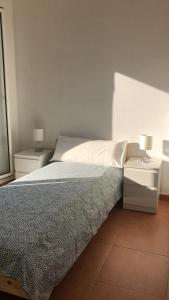 1 dormitorio con 1 cama con 2 mesitas de noche y 2 lámparas en Ático en Gràcia, en Barcelona