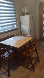 a wooden table with two chairs and a refrigerator at Queens house in Oświęcim