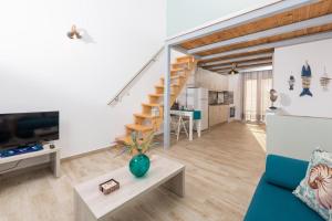 a living room with a staircase and a couch at Artemis Beach Apartments in Chrysi Ammoudia