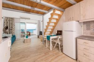 a kitchen and living room with a staircase in a room at Artemis Beach Apartments in Chrysi Ammoudia