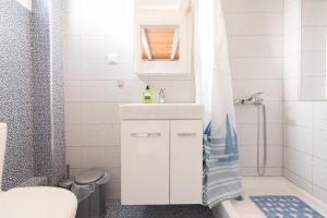 a bathroom with a sink and a toilet and a shower at Artemis Beach Apartments in Chrysi Ammoudia +30 photos