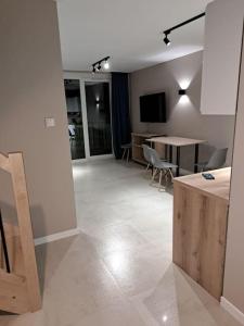 een woonkamer met een keuken en een eetkamer bij Baltic Garden apartament dwupoziomowy 56 m² in Sztutowo