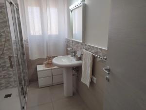 a bathroom with a sink and a shower and a mirror at GiErre Apartment in Termini Imerese