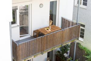 a balcony with a wooden table on a house at Cozy City Apartment in Graz