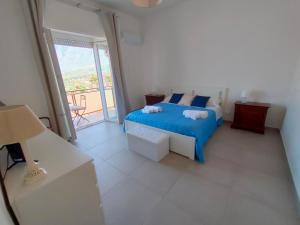 a bedroom with a blue bed and a balcony at GiErre Apartment in Termini Imerese