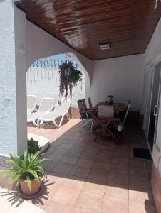 een patio met stoelen en een tafel en de oceaan bij Beautiful Holiday Villa with heated private pool, Los Cristianos in Los Cristianos