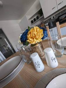 a table with a vase with a yellow flower on it at Holiday home in City Centre in Liverpool