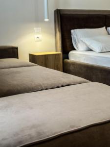 two beds sitting next to each other in a room at ALEXANDER Rooms & Apartments in Durrës