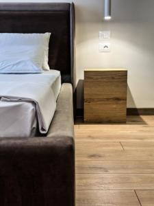 a bed with a black headboard and a wooden floor at ALEXANDER Rooms & Apartments in Durrës