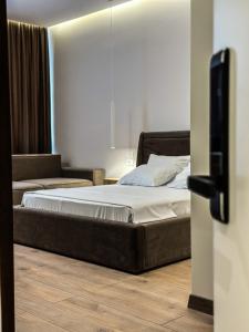 a bedroom with a bed and a tv on the floor at ALEXANDER Rooms & Apartments in Durrës