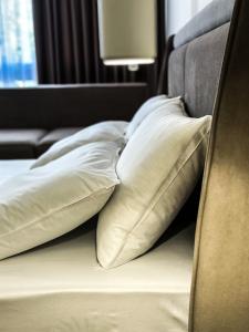 a group of pillows sitting on a bed at ALEXANDER Rooms & Apartments in Durrës