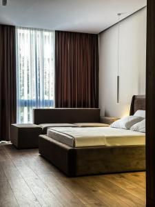 1 Schlafzimmer mit 2 Betten und einem großen Fenster in der Unterkunft ALEXANDER Rooms & Apartments in Durrës