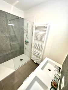 a white bathroom with a shower and a sink at European Comission Beautiful Studio in Brussels