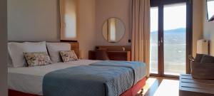 a hotel room with a bed and a large window at PENEMA VILLA in Hersonissos