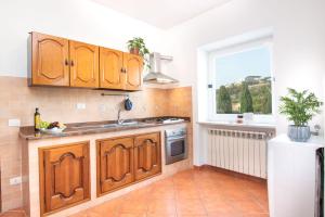 eine Küche mit Holzschränken und einem Fenster in der Unterkunft Simonelli Apartments in Ischia