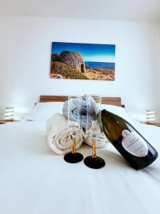 eine Flasche Wein und eine Decke auf dem Bett in der Unterkunft Villetta Privata in Salento a 15minuti da Gallipoli in Casarano