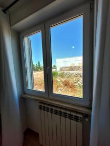 - une fenêtre dans une pièce avec un radiateur et une vue dans l'établissement Villetta Privata in Salento a 15minuti da Gallipoli, à Casarano