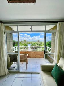 a living room with a couch and a large window at Flat Gran Lençóis in Barreirinhas