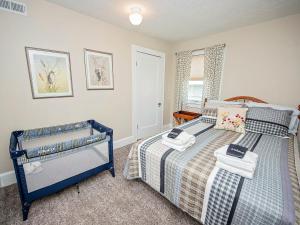 Un dormitorio con una cama azul con toallas. en The Cherry St House/Great amenities/near MSU en Springfield