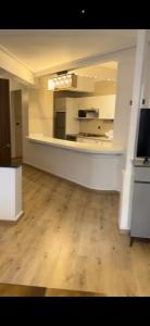 - un salon vide avec du parquet et une cuisine dans l'établissement apartment 100m2 center malabata, à Tanger