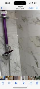 une capture d'écran d'une salle de bains avec un rasoir violet dans l'établissement apartment 100m2 center malabata, à Tanger