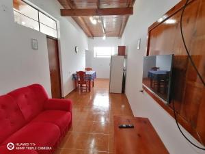 sala de estar con sofá rojo y mesa en La Mulata Apart en Puerto Iguazú