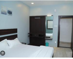 a bedroom with a bed and a mirror and a television at Hotel Rahul Regency, Aurangabad in Aurangabad