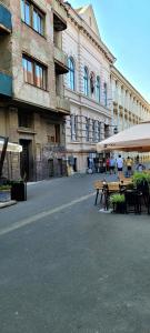 uma rua da cidade vazia com mesas e um edifício em Pacha Residence em Timisoara