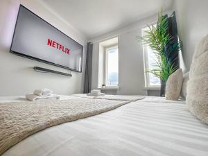 uma grande cama branca com uma televisão na parede em Residential Hotels Helsinki Penthouse em Helsínquia