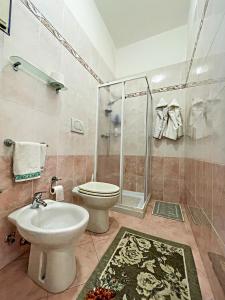 y baño con aseo, lavabo y ducha. en B&B La Perla, en Castro di Lecce