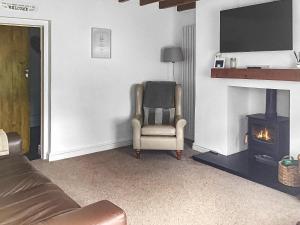 a living room with a chair and a fireplace at Pen Y Bont in Rhuddlan