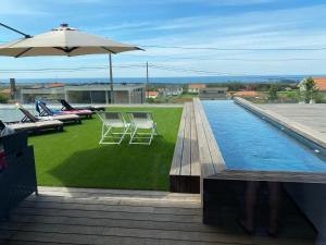 uma piscina com cadeiras e um guarda-sol no telhado em PEARL by Balgrid em Viana do Castelo