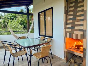 a dining room with a table and chairs and a fireplace at Cabañas con jacuzzi y chimenea - Casa Floral, Marinilla in Marinilla