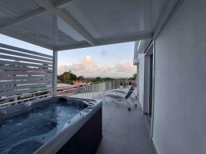 ル・ゴジエにあるVilla Blue Sunrise Pool & Jacuzzi 5mn de la merの建物のバルコニーにある温水浴槽